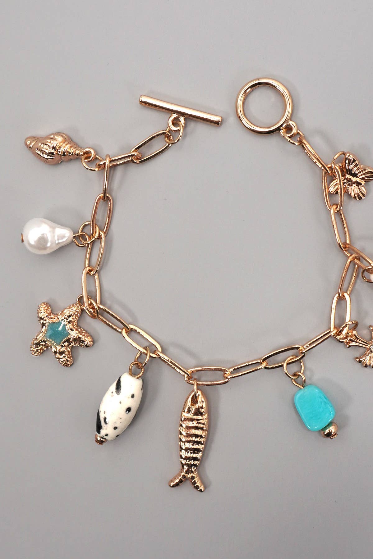 CHARM TOGGLE BRACELET-FISH CROSS CONCH PEARL | GOLD
